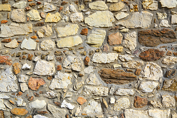 Image showing Old wall texture of various stones lit by the sun