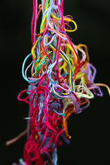 Image showing Multicolored tangled threads for needlework on black background