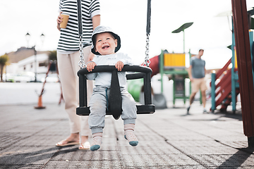 Image showing Mother pushing her infant baby boy child on a swing on playground outdoors.