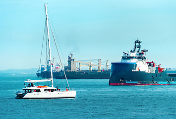 Image showing Freight ships and white yacht