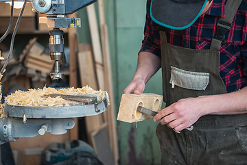 Image showing Carpenters with electric drill machine drilling wooden board