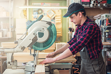 Image showing Carpenter worker cutting wooden board