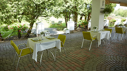 Image showing terrace summer cafe with tables and chairs for people, an empty institution for recreation, nobody