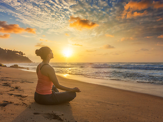 Image showing Woman doing yoga oudoors at beach - Padmasana lotus pose