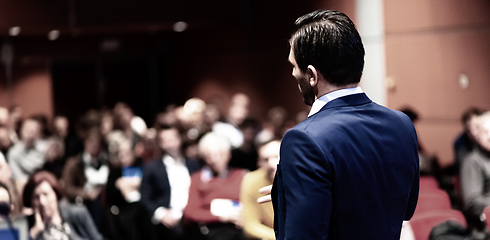 Image showing Speaker giving a talk on corporate Business Conference. Audience at the conference hall. Business and Entrepreneurship event