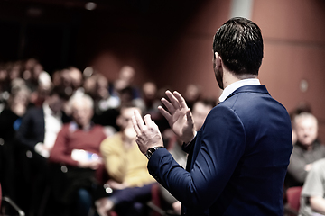 Image showing Speaker giving a talk on corporate Business Conference. Audience at the conference hall. Business and Entrepreneurship event