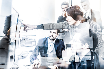 Image showing Business team looking at data on multiple computer screens in corporate office. Businesswoman pointing on screen. Business people trading online. Business, entrepreneurship and team work concept