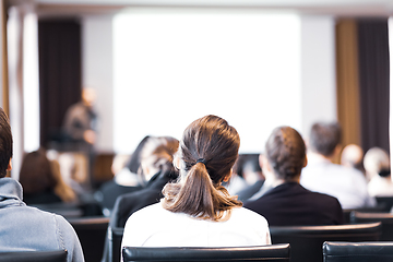 Image showing Speaker at Business Conference and Presentation. Audience in the conference hall. Business and Entrepreneurship. Copy space on white screen