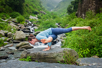 Image showing Woman doing yoga oudoors at tropical waterfall