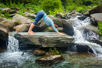 Image showing Woman doing yoga oudoors at tropical waterfall