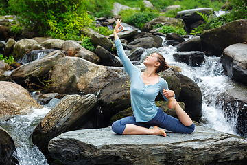 Image showing Woman doing yoga outdoors at tropical waterfall