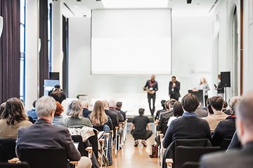 Image showing Business team leader receiving award prize at best business project competition event. Business and entrepreneurship award ceremony theme. Focus on unrecognizable people in audience.