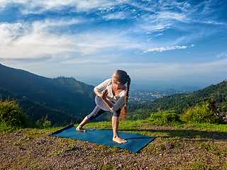 Image showing Woman practices yoga asana Utthita Parsvakonasana