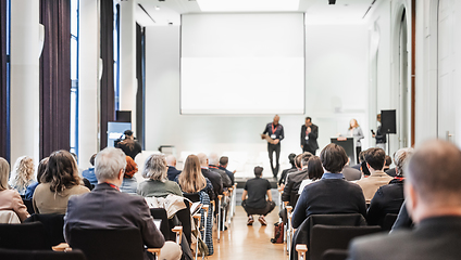 Image showing Business team leader receiving award prize at best business project competition event. Business and entrepreneurship award ceremony theme. Focus on unrecognizable people in audience.