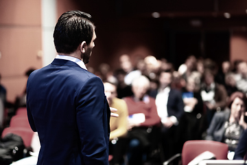 Image showing Speaker giving a talk on corporate Business Conference. Audience at the conference hall. Business and Entrepreneurship event