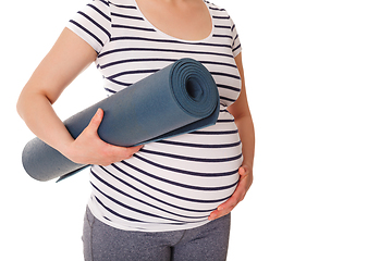 Image showing Pregnant woman standing with yoga mat