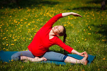 Image showing Pregnant woman doing asana Parivrtta Janu Sirsasana outdoors