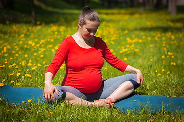 Image showing Pregnant woman doing asana baddha konasana outdoors