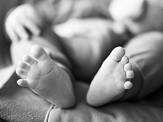 Image showing Close-up of cute little baby feet, innocence concept. Black and white image.