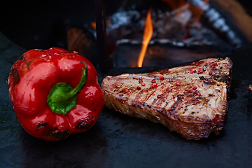 Image showing Grilled T-Bone Steak on serving board on wooden background