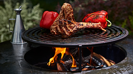 Image showing Tomahawk rib beef steak and T-bone on hot black grill.