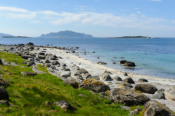 Image showing beach with rocks and grass on the coast with islands in the dist