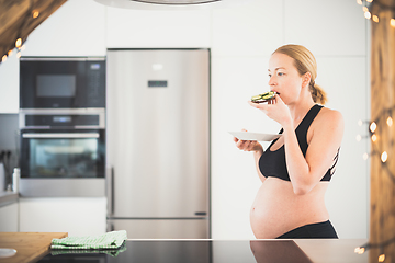 Image showing Beautiful sporty fit young pregnant woman having a healthy snack in home kitchen. Healty lifestyle concept.