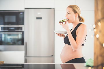 Image showing Beautiful sporty fit young pregnant woman having a healthy snack in home kitchen. Healty lifestyle concept.