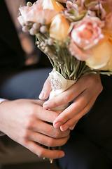 Image showing Groom holding in hands delicate, expensive, trendy bridal wedding bouquet of flowers