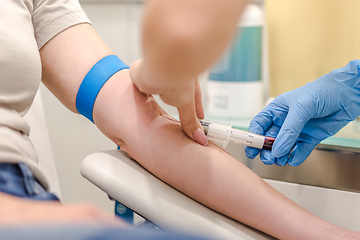 Image showing Close-up Of Doctor Taking Blood Sample From Patient's Arm in Hospital for Medical Testing.