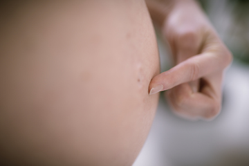 Image showing Pregnant Woman Belly. Pregnancy Concept. Pregnant tummy close up with finger pointing on belly button.