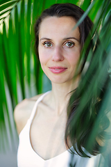 Image showing Young beautiful natural cheerful woman with healthy face and skin in exotic greenery. Closeup fresh face of attractive girl. Summer model. Natural beauty concept