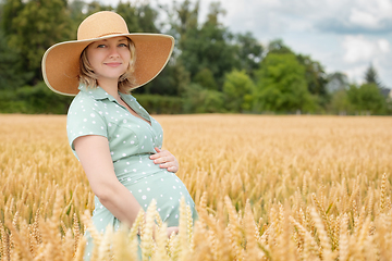 Image showing Pregnant woman in hat in field of wheat