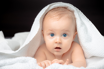 Image showing Cute baby with blue eyes lying on bed