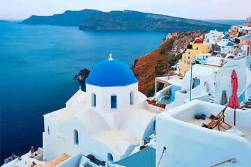 Image showing Famous view from viewpoint of Santorini Oia village with blue dome of greek orthodox Christian church