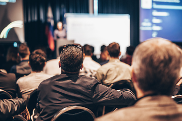 Image showing Speaker giving a talk in conference hall at business event. Rear view of unrecognizable people in audience at the conference hall. Business and entrepreneurship concept.