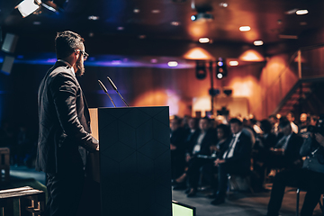 Image showing Speaker giving a talk on corporate business conference. Unrecognizable people in audience at conference hall. Business and Entrepreneurship event