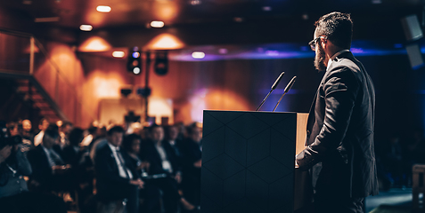 Image showing Speaker giving a talk on corporate business conference. Unrecognizable people in audience at conference hall. Business and Entrepreneurship event