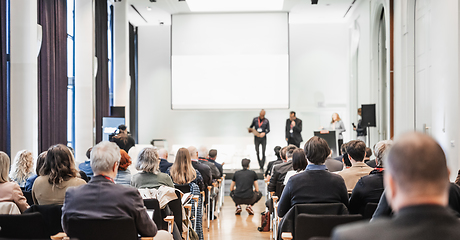 Image showing Business team leader receiving award prize at best business project competition event. Business and entrepreneurship award ceremony theme. Focus on unrecognizable people in audience.