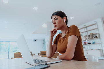 Image showing Woman sitting in living room using laptop look at cam talk by video call with business friend relatives, head shot. Job interview answering questions.