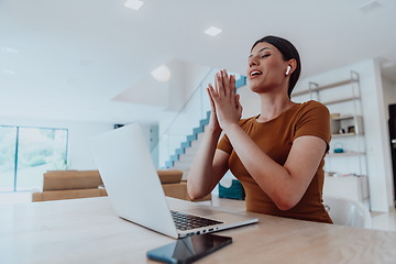 Image showing Woman sitting in living room using laptop look at cam talk by video call with business friend relatives, head shot. Job interview answering questions.