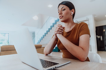 Image showing Woman sitting in living room using laptop look at cam talk by video call with business friend relatives, head shot. Job interview answering questions.