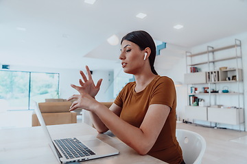 Image showing Woman sitting in living room using laptop look at cam talk by video call with business friend relatives, head shot. Job interview answering questions.