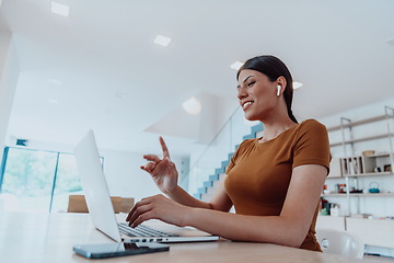 Image showing Woman sitting in living room using laptop look at cam talk by video call with business friend relatives, head shot. Job interview answering questions.