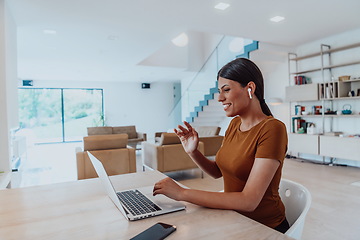 Image showing Woman sitting in living room using laptop look at cam talk by video call with business friend relatives, head shot. Job interview answering questions.