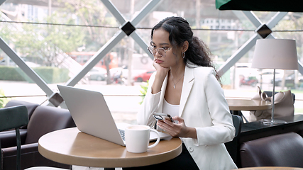 Image showing Professional Woman Working Remotely with Wireless Technology in a Cozy Cafe