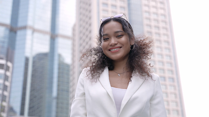 Image showing Smiling Businesswoman Outside Corporate Skyscraper in the City.