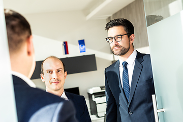 Image showing Group of confident business people greeting with a handshake at business meeting in modern office or closing the deal agreement by shaking hands.