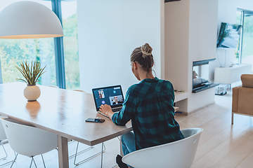 Image showing Woman sitting in living room using laptop look at cam talk by video call with business friend relatives, head shot. Job interview answering questions.