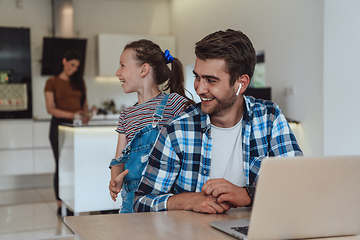 Image showing Father and daughter in modern house talking together on laptop with their family during holidays. The life of a modern family